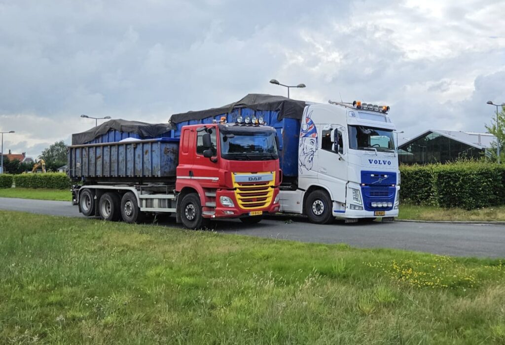 Rode DAF-vrachtwagen en witte Volvo-vrachtwagen