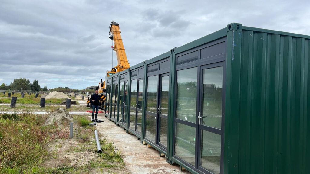 Groene containerunit met grote ramen